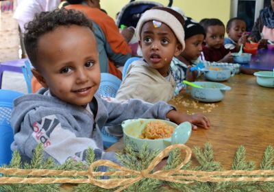 children sitting at table eating lunch at daycare in Ethiopia