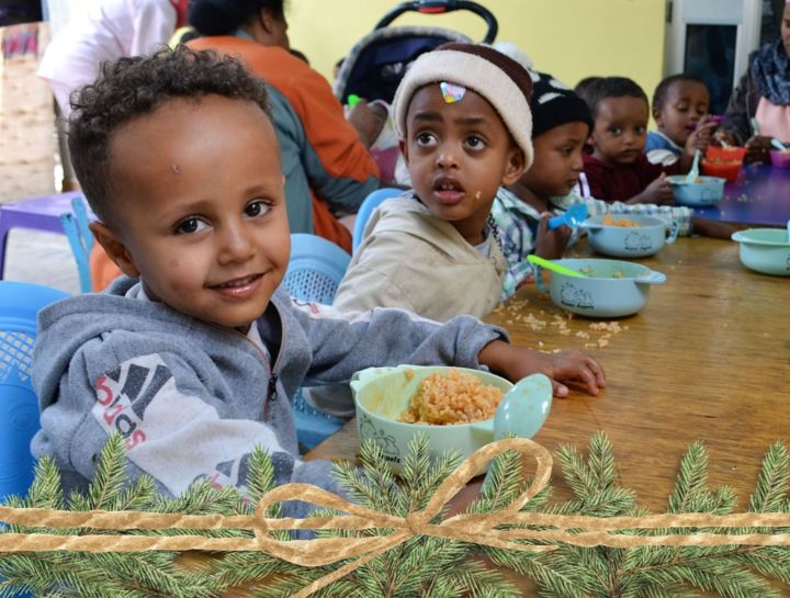 children sitting at table eating lunch at daycare in Ethiopia