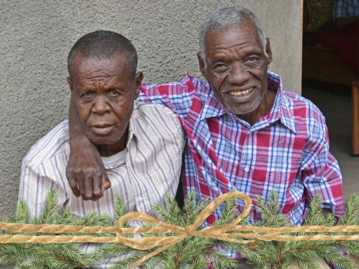 Two older men with leprosy with new shirts