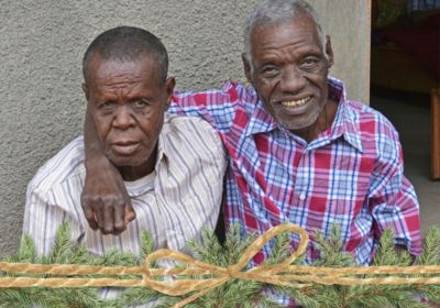 Two older men with leprosy with new shirts