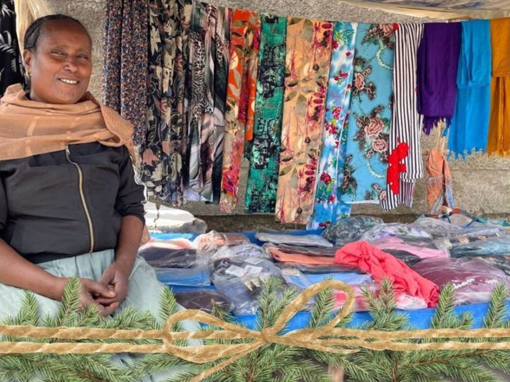 Ethiopian woman sitting at her clothing business stall on street